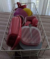 Basket containing assorted storage containers, bowls, utensils