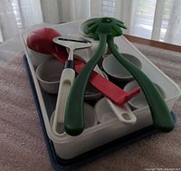 Utensils and bowls inside white plastic tub