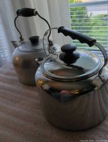 Front view of both kettles showing lids and handles