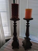 Both candlesticks with pillar candles displayed by window