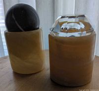 Both stone candle holders with tops attached side by side