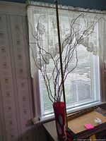 Full view of vase on table with branches and measuring tape