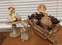 Overall view showing wheelbarrow display, birdbath stand with bunny and cat, and ceramic dog