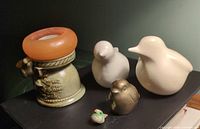 Group shot of candle holder, two white ceramic birds, brass bird and miniature bird
