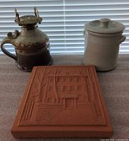 Group view of plaque, crock and oil lamp
