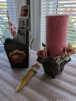 Overview showing metal holder with bookmarks, letter opener, candle on stand