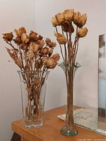 Both vases with dried roses on tabletop