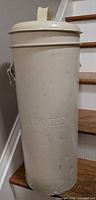 Full view showing canister with lid on stair step