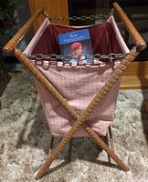 Full view of wooden folding caddy with pink fabric and chain handles