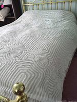 Full view of white chenille bedspread on queen bed