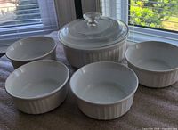 Group shot showing casserole with lid and four ramekins