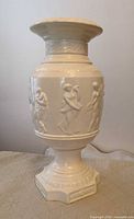 Full view of white porcelain vase showing overall form and relief decoration