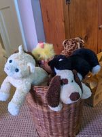 Hamper filled with assorted plush toys visible at top