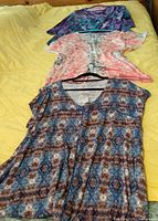 All three knit tops laid out showing prints, colors, sleeve and neck styles