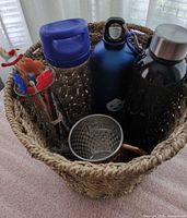 Overall view of basket with bottles, mug and vase inside