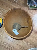 Top view of wooden butter bowl with ladle inside