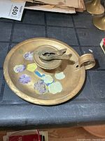 Top view of metal chamberstick showing floral paint and clip
