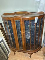 Front view of antique curved-glass display cabinet