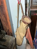 Full view hanging golf bag showing canvas body and leather strap