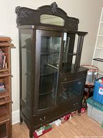 Front view of entire cabinet showing curved glass door, right side shelves, base drawer