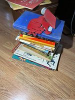 Stack of assorted reference books with one metal bookend on top