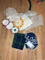 Group shot of crocheted doilies, plaid scarf and knit toque