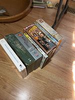 Stack of seven boxed DVD sets on hardwood floor