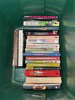 Top view of stacked hardcover novels inside green tote