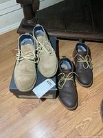 Tan suede pair on box, brown leather pair beside