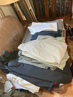 Folded pants, shirts, jacket stacked on luggage