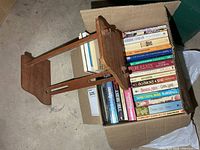 Box of paperbacks and wooden rack top view