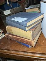 Stack of five clothbound hardcover books on table