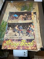 Front cover of scrapbook showing colour hockey action photos and spine wear