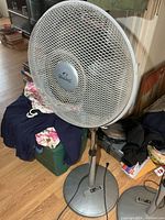 Full view of WindChaser pedestal fan showing base, pole, and grille