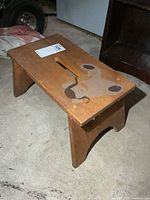 Top view of vintage wooden step stool showing handle slot and painted dog graphic