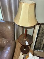 Full view of wooden floor lamp with shade and built-in table