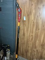 Full view of Homelite telescopic pole saw leaning against wall