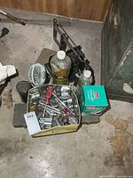 Group showing tin of sockets, lamp oil, fan, miter saw, boxed floodlight