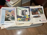 Stacks of loose vintage ad pages showing O'Keefe's convoy ad and Goodyear tire ad