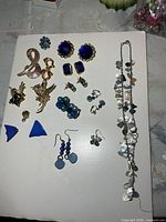 Full lot overview showing necklace, brooches, multiple pairs of earrings