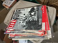 Stack of Life magazines on bin lid, top issue July 11 1954