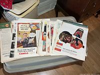 Stacks of loose vintage magazine ads showing Camel and Winston examples