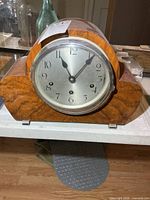 Front view of wooden mantel clock showing dial and case
