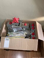 Box containing assembled metal castle sections with red turret tops and bags of figures