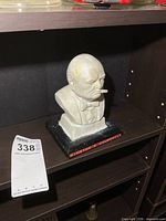 Front view of Winston Churchill wooden bust on shelf