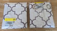 Two packaged Bouclair Pegaze curtain panels on cardboard