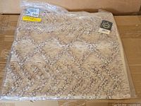 Factory-sealed Surya pillow cover on box