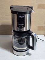 Front view showing full coffee maker, carafe attached, power cord visible