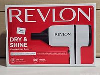 Front of sealed retail box showing Revlon Dry & Shine compact hair dryer, model details and wattage