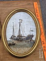 Right frame showing European galleon ship print in gold oval frame beside yardstick